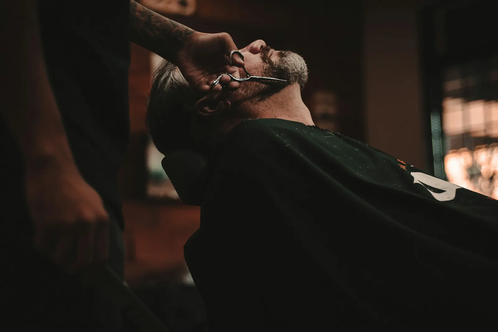 Barbeiro fazendo o acabamento da barba de um cliente